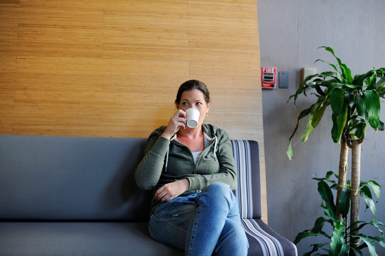 Businesswoman sitting near office plant